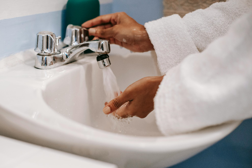 Person washing their hands in the sink