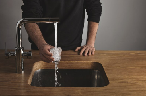 A man filling a glass with water.