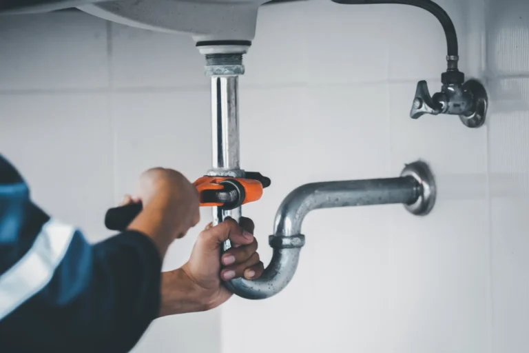 Professional plumber repairing water pipes in a residential basement