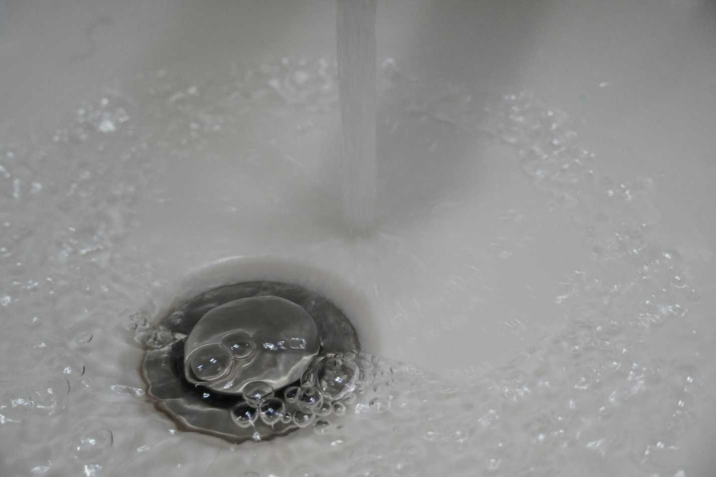 A silver drain in a sink