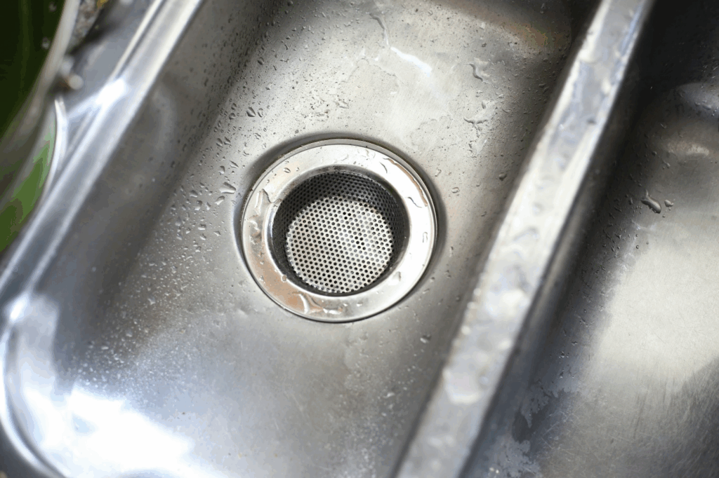 A drain in a stainless steel sink