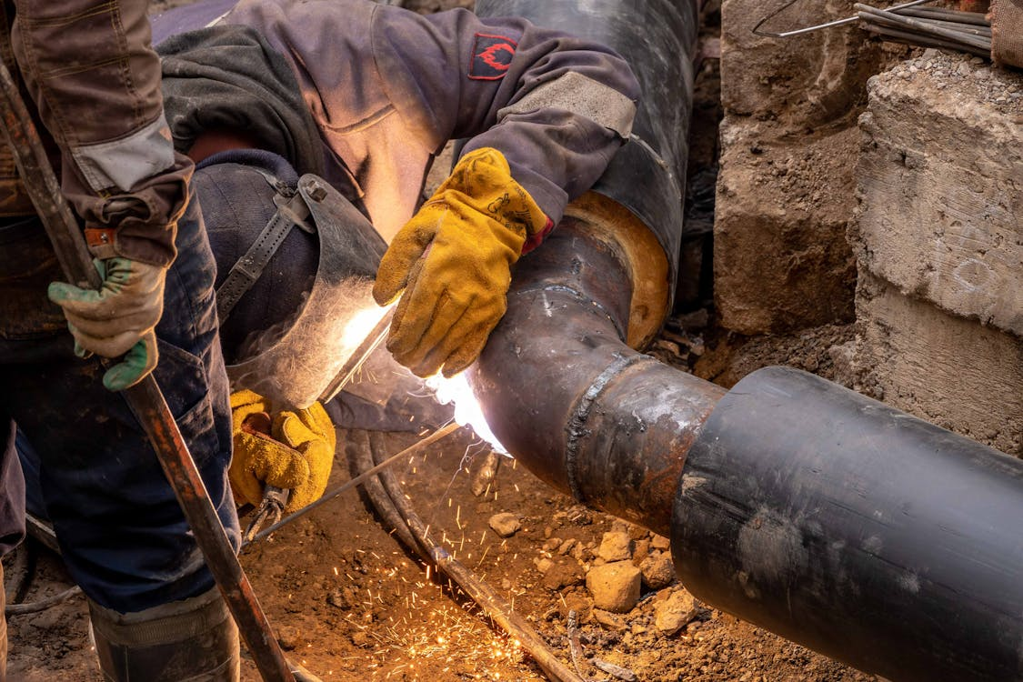 Professional plumbers replacing underground pipes at a commercial property