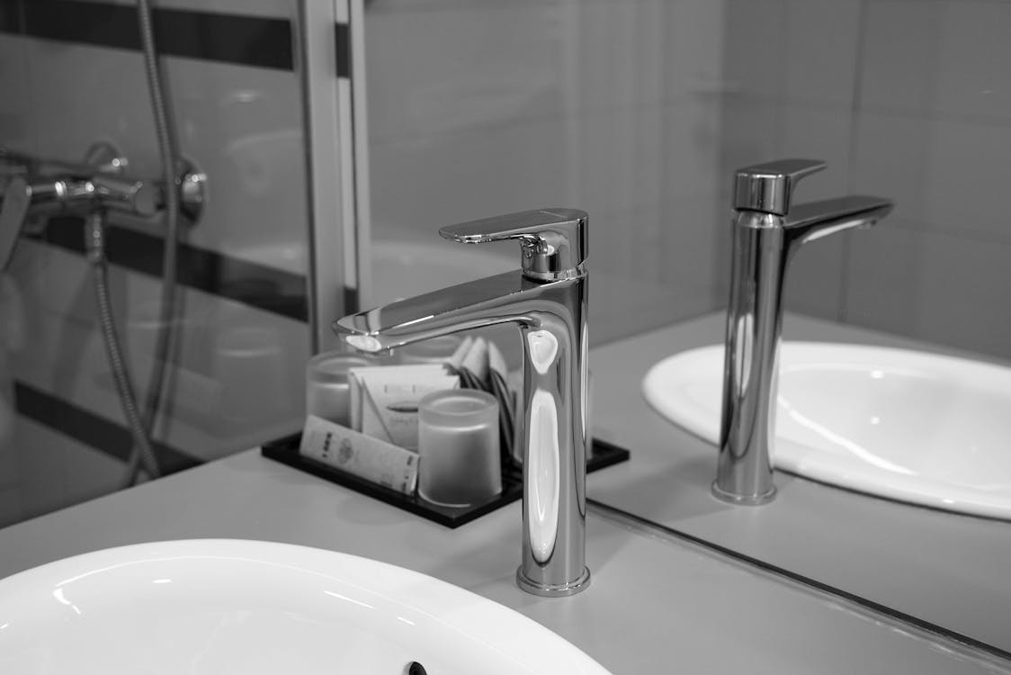 A black-and-white picture of a faucet and sink 