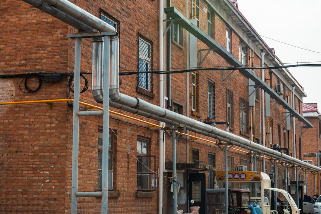 Exterior sewer pipes along an older commercial building.