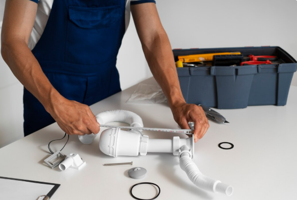 A technician performing sewer and drain cleaning in Massapequa, NY, while checking household pipes. 
