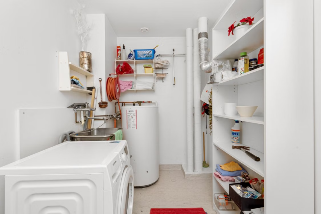 A tank-style storage water heater, checked at the base where end-of-life leaks begin.