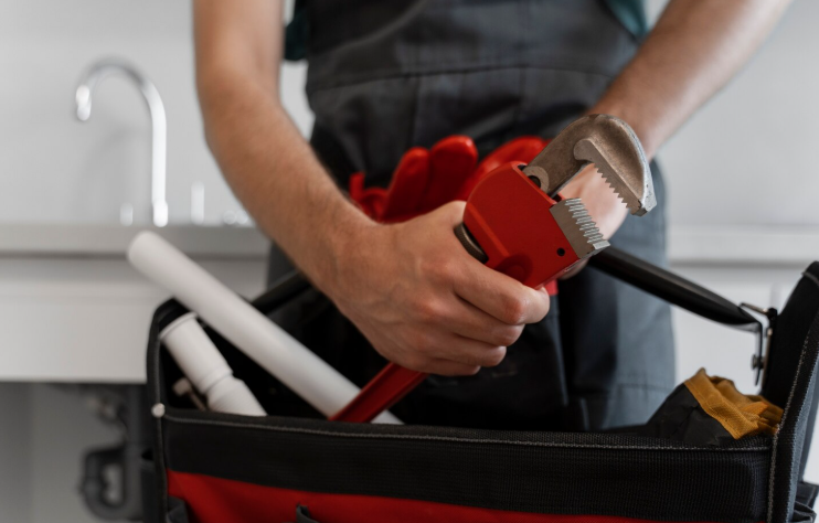 Professional plumber keeping tools back after plumbing service in Long Island